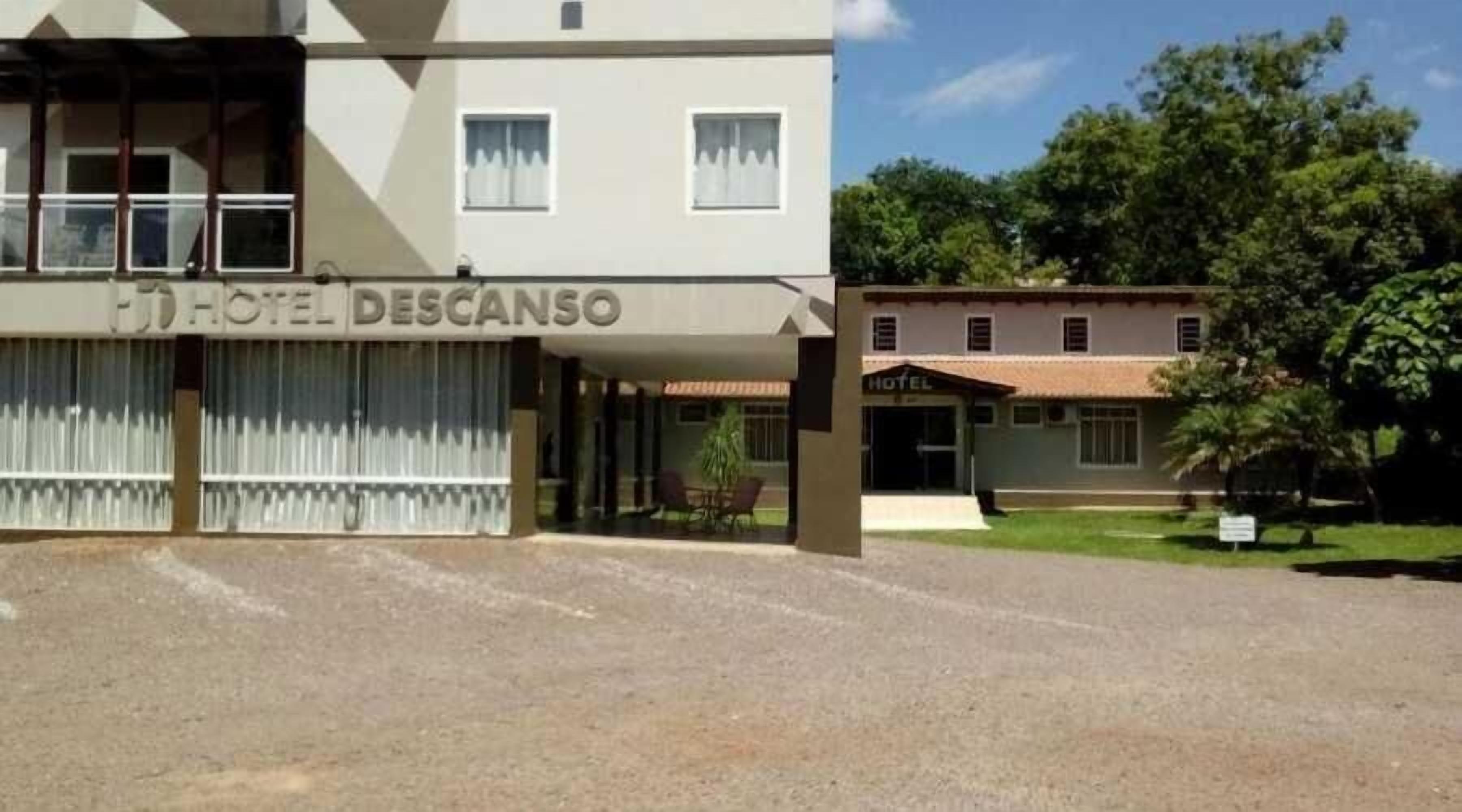 A hotel named 'HOTEL DESCANSO' with a covered entrance and a visible outdoor seating area.