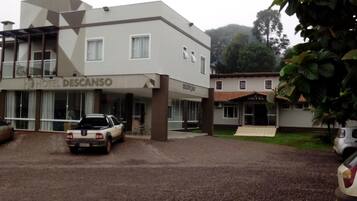Hotel de dos pisos con un diseño moderno, con un coche estacionado en la entrada.