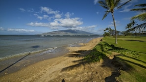 A beach with a clear view of the ocean, a sandy shore, and a distant mountain. - Gorgeous Ground Floor Oceanfront Condo, Just Steps Away From Pool & Beach! (Kihei)
