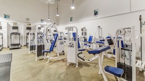 A gym with various exercise machines, treadmills, and weightlifting equipment. - BT 3843 Ocean View Condo-Paradise Vacation Rental in Ocean Village (Fort Pierce)
