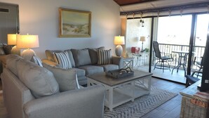 A living room with a sofa, armchairs, a coffee table, and a painting on the wall. - BT 3843 Ocean View Condo-Paradise Vacation Rental in Ocean Village (Fort Pierce)