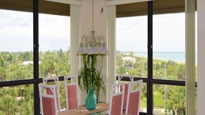 A balcony with a table, chairs, and a potted plant. - SS 4152 Ocean View Condo- in Ocean Village (Fort Pierce)