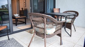 Un espace patio aménagé avec des meubles en osier, une table et des chaises.
