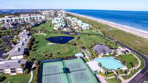 An aerial view of a resort with multiple buildings, a tennis court, and a beach. - CP 315 Dune View Condo -Paradise Vacation Rental in Ocean Village (Fort Pierce)