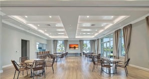 A spacious conference room with a long table and chairs, large windows, and a modern ceiling design.