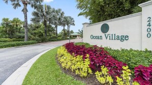 Une enseigne indiquant l’entrée d’Ocean Village, avec un jardin aménagé devant.