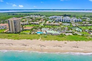 Un complexe hôtelier comprenant plusieurs bâtiments, une plage et un espace piscine.