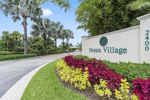 Segnaletica per Ocean Village, con un giardino curato di fronte.
