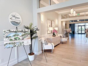 Experience the elegant lobby with a reception desk, comfortable seating area, and beautiful artwork on display.