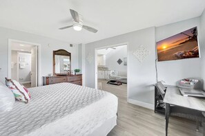 A bedroom with a bed, a desk, a chair, a ceiling fan, and a wall-mounted TV. - GV 5123 Golf Course View Condo-Welcome to Paradise (Fort Pierce)