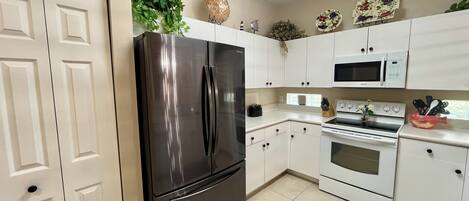 A modern kitchen with white cabinets, stainless steel appliances, and decorative items.