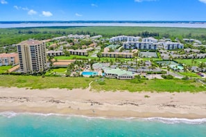 Resort com vários edifícios, uma praia e uma ampla área de piscina.