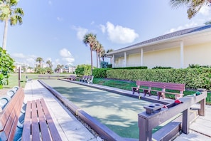 Un espace piscine avec des bancs et un bâtiment en arrière-plan.