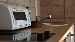 Una cocina con un tostador, una cesta de utensilios y un lavamanos.