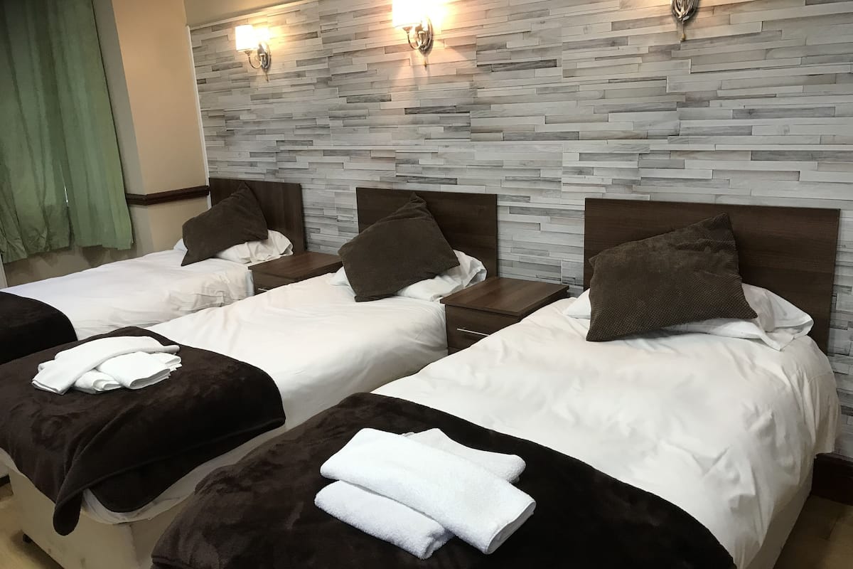 Habitación triple Deluxe, baño privado | Camas Select Comfort, escritorio, wifi gratis y ropa de cama