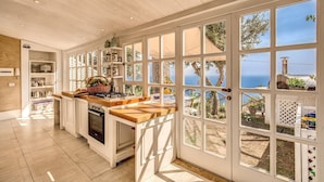 A spacious kitchen with large windows offering a view of the sea and a garden. - VILLA COSTIERA - Five Bedroom Villa, Sleeps 10 (Amalfi)
