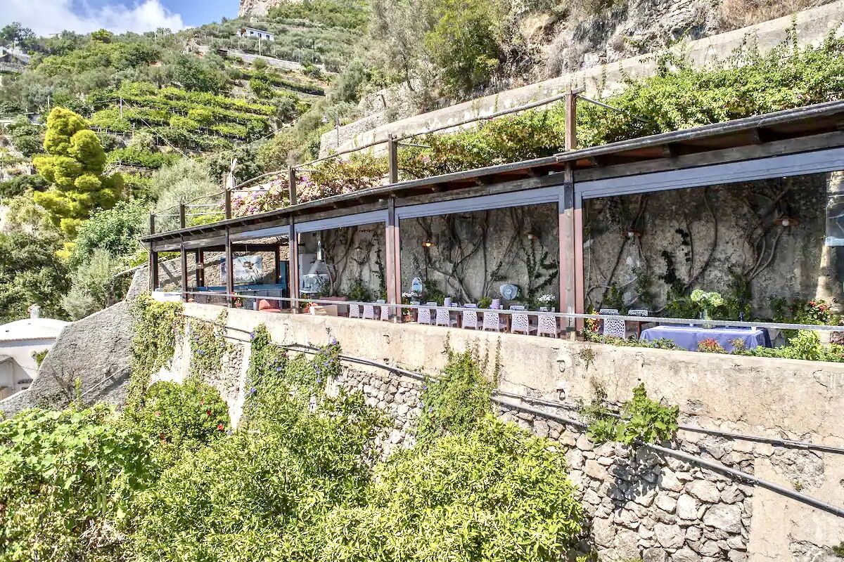 Un edificio lungo e stretto con facciata in pietra e una serie di finestre.