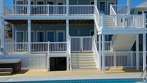 A multi-story waterfront property with balconies, a pool, and a staircase leading to the upper levels. - Oceanfront 9 bdrms with pool and hot tub (Carolina Beach)