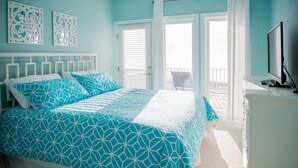 A bedroom with a bed, a TV, and a balcony. - Oceanfront 9 bdrms with pool and hot tub (Carolina Beach)