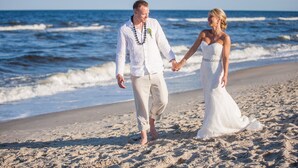 A couple walking hand in hand on a sandy beach with the ocean in the background. - Oceanfront 9 bdrms with pool and hot tub (Carolina Beach)
