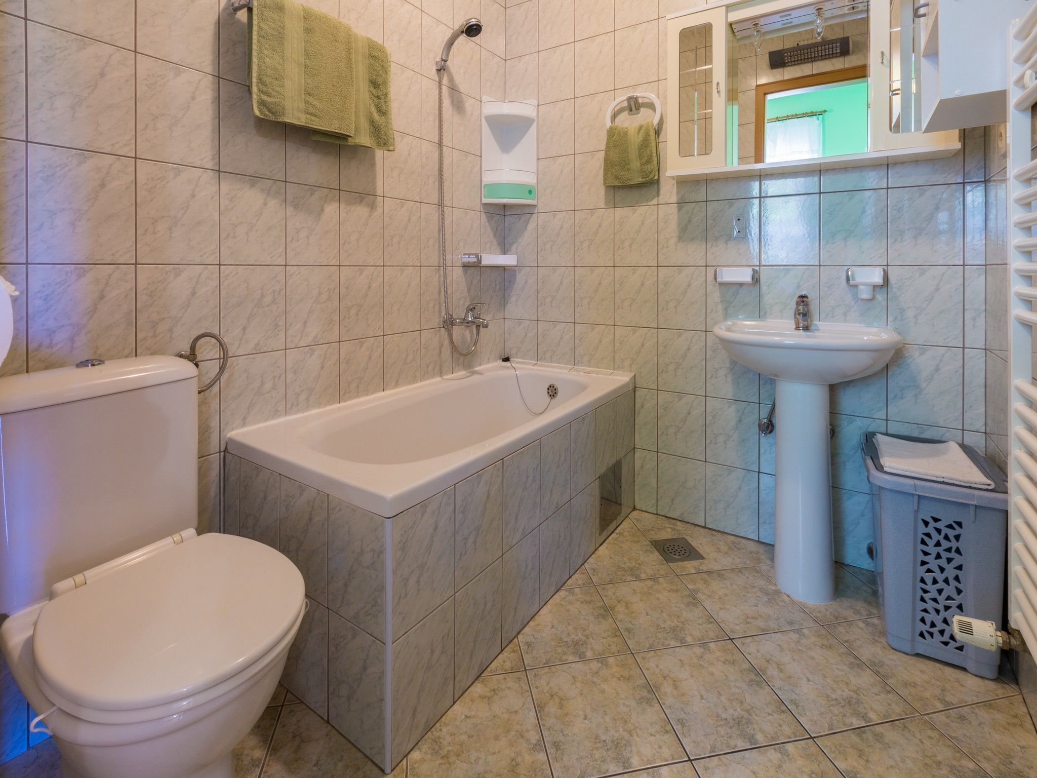 A bathroom with a toilet, bathtub, and sink.