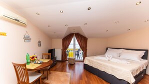 Ein Hotelzimmer mit Bett, Esstisch, Stühlen und Blick ins Freie.