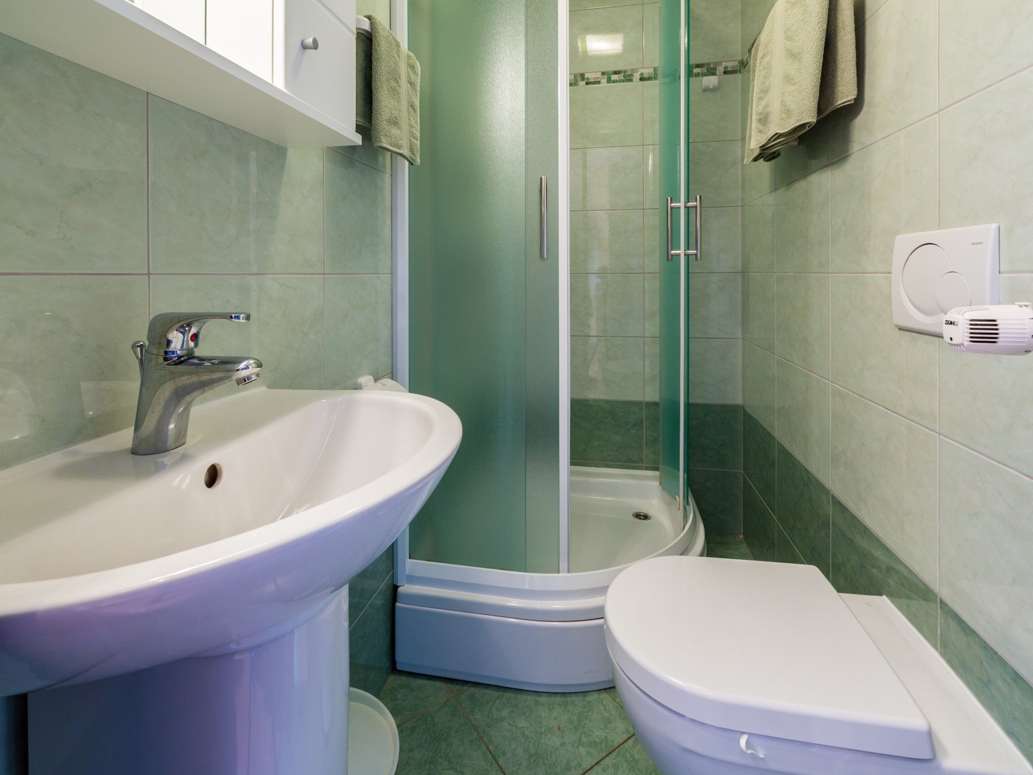 Ein Badezimmer mit Waschbecken, Toilette und einer Duschkabine.