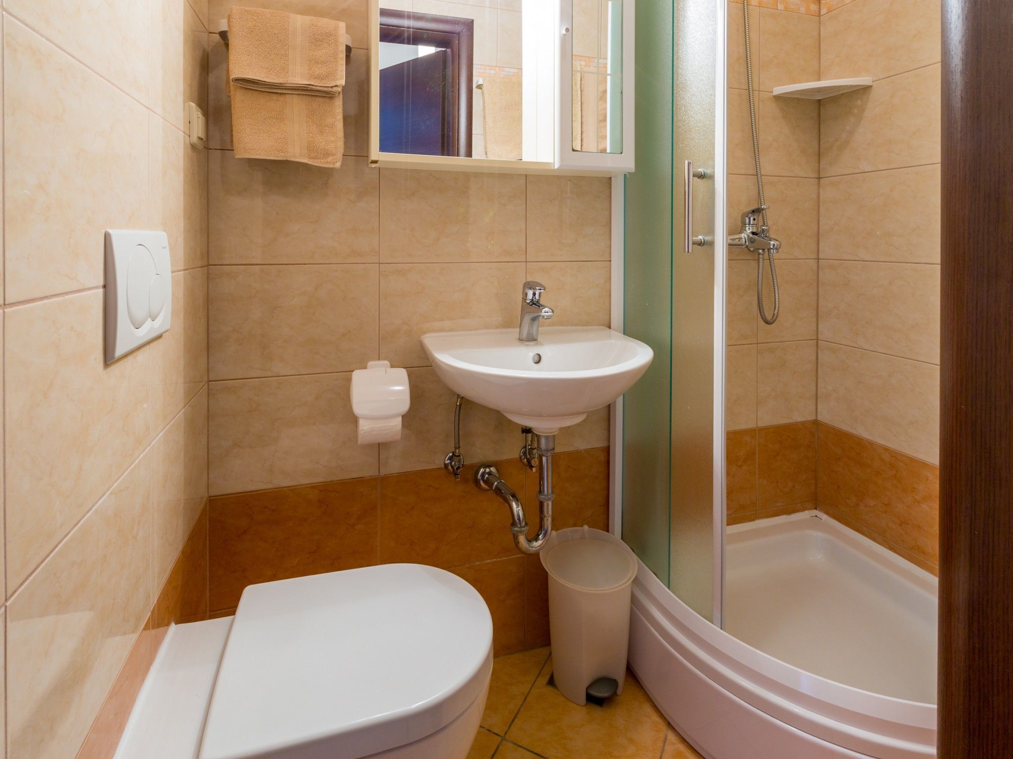 A bathroom with a toilet, sink, and shower.