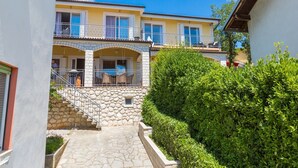 A two-story building with a stone staircase leading to a balcony. - Apartments Franco (Selce)