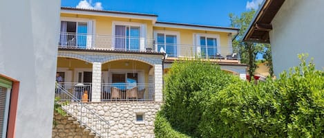 Un bâtiment à deux étages avec un escalier en pierre menant à un balcon.
