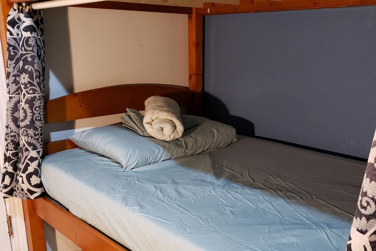 A bunk bed with a rolled towel on the lower bunk.