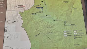 Un mapa de un parque con senderos, zonas de picnic y una estación de guardaparques.