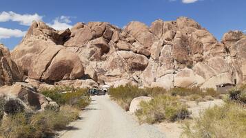 Un paisaje rocoso con un sendero de grava que conduce hacia grandes rocas y vegetación escasa.