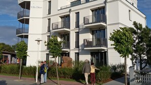 Un immeuble moderne à plusieurs étages, doté de balcons et d’une entrée couverte.