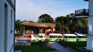 Une cour avec un restaurant, des tables en plein air et une pelouse verdoyante.