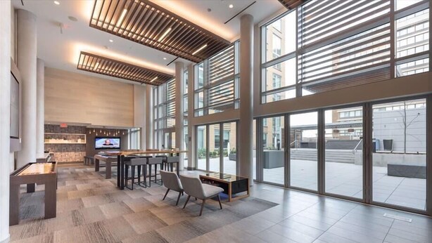 A spacious lobby with a pool table, seating area, and large windows offering views of the city. - Modern 2BR | Full Kitchen | Near Crystal City Shops | By GLS (Arlington)
