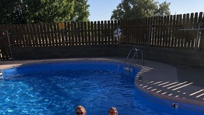 Piscina com duas pessoas em um boi de rosa.