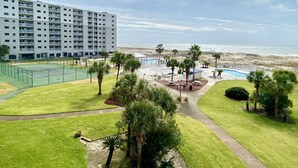 Ett semesterhotell med tennisbana, poolområde och utsikt över stranden.