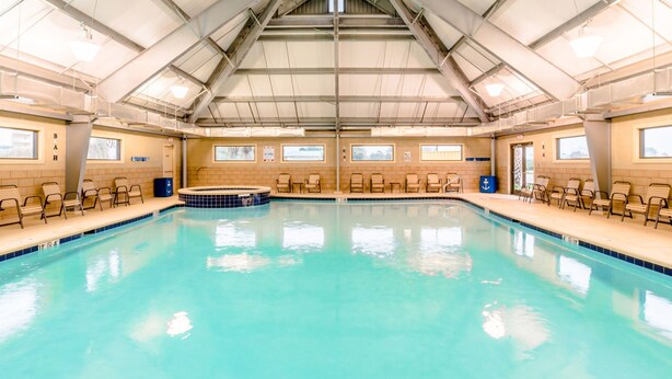 En stor inomhuspool med högt tak och många fönster.
