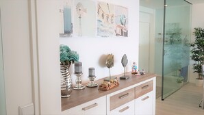 Una cocina moderna con encimera de madera, puerta de cristal que da a un comedor y decoración artística en la pared.