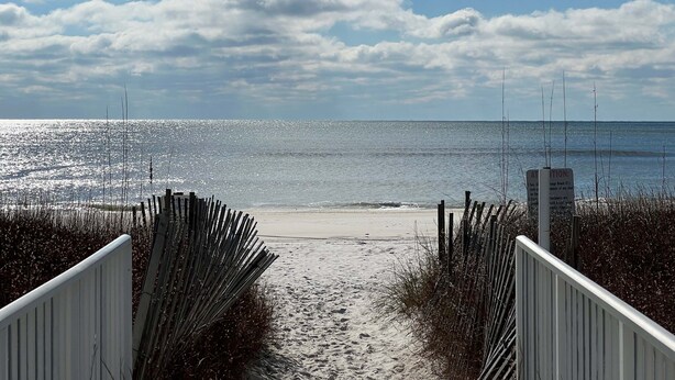 A beach path leading to the shore with a signboard. - Sugar Beach Condos by ALBVR (Orange Beach)