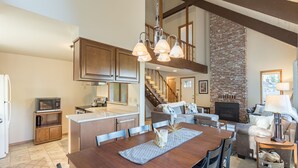 A spacious kitchen with wooden cabinets, a central island, and a dining area with a wooden table and chairs. - Mt Hood Escape, 3 bedroom, 2 bath, plus loft, sleeps 10, hot tub  (Mt Hood Village)