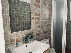 A bathroom with a white sink, a mirror, and a toilet. - Ocean view apartment (Santiago del Teide)