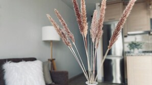 A living room with a sofa, a vase with dried pampas grass, and a lamp. - Ocean view apartment (Santiago del Teide)
