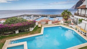 A swimming pool with a view of the sea and marina. - Ocean view apartment (Santiago del Teide)
