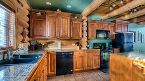 Una cocina con armarios de madera, lavavajillas, estufa y refrigerador.