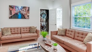 Een moderne woonkamer met twee leren banken, een salontafel en een schilderij van een stadsgezicht.