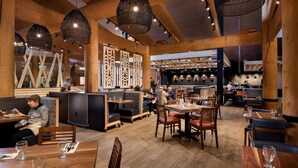 A restaurant with wooden beams, hanging wicker lamps, and a counter area with masks displayed on the wall. - 7 Cedars Hotel & Casino (Sequim)