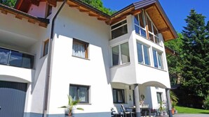 A two-story house with a balcony, large windows, and a garage. - Wennserblick by Interhome (Wenns)