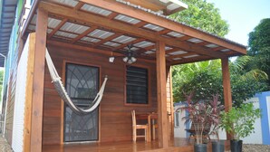 A wooden house with a covered porch, a hammock, and potted plants. - Latitude 17 Garden Room, heart of Hopkins Village, Belize (Hopkins Village)